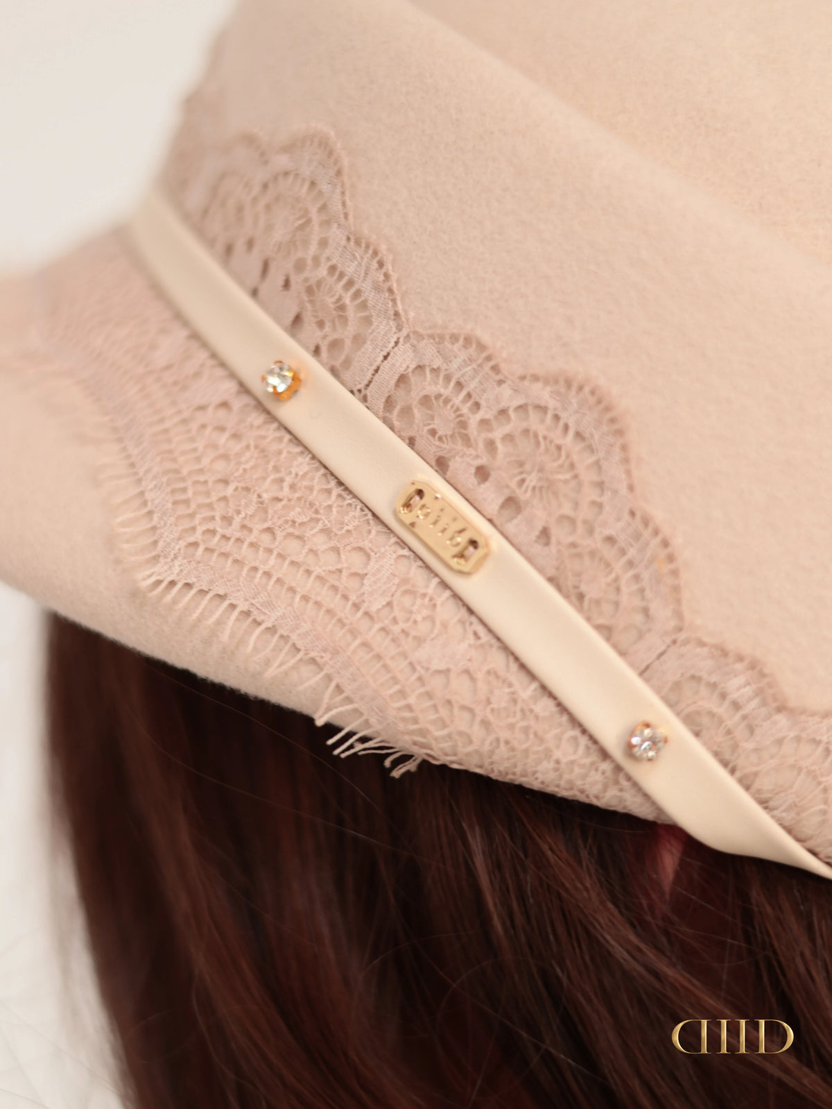 Gold-tone DIID detail on the hat strap, worn