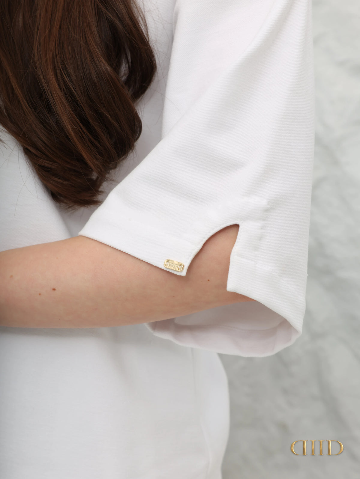 Elbow-length sleeve with a small slit and the gold-tone DIID tag