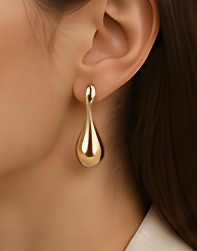 DIID champagne-gold sculpted drop earring worn with an ivory top